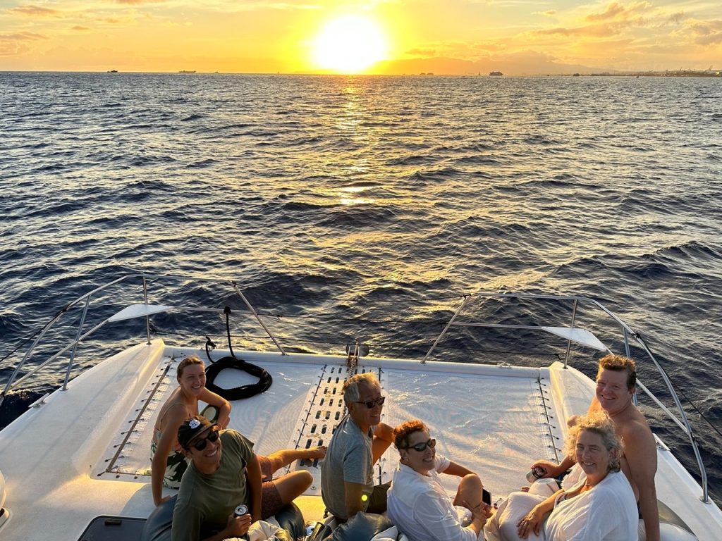 Visitors enjoying a sunset cruise while on a Honolulu city tour.