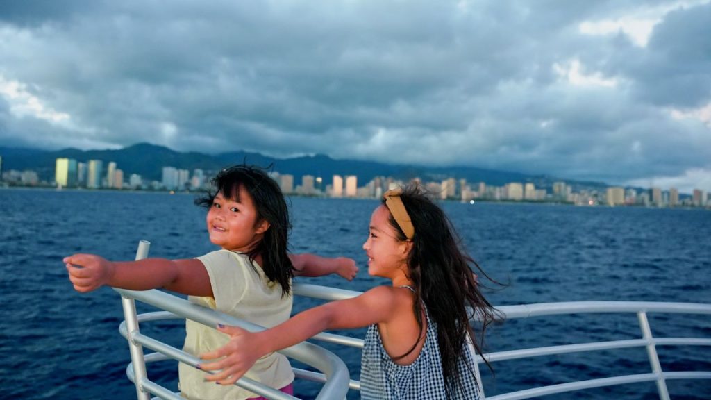 Two girls enjoying a cruise: one of the best things to do in Oahu with kids.
