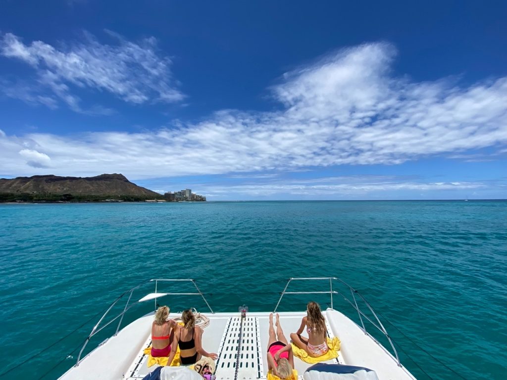 Tourists enjoying a Hawaii boat ride with ocean views.