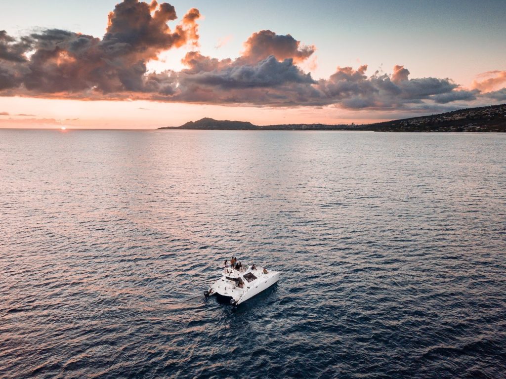 Waikiki skyline view with a boat sailing on calm blue water.