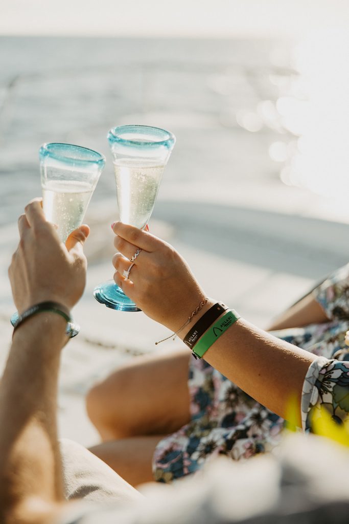 Couple celebrating together with wine on a sunset cruise in Hawaii. 