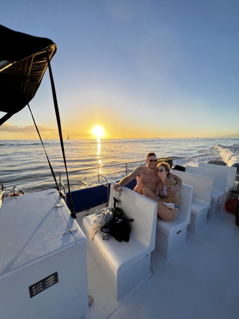 Couple embracing each other during a sunset cruise ride. 