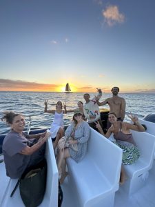Friends celebrating sunset aboard Waikiki catamaran cruise