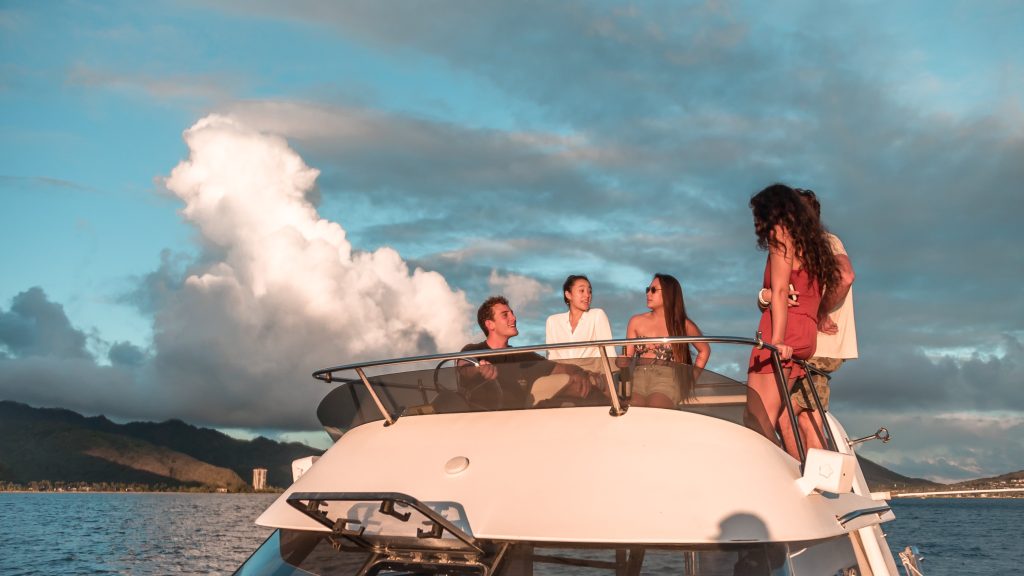Guests enjoying an Oahu sunset cruise with ocean and skyline views.