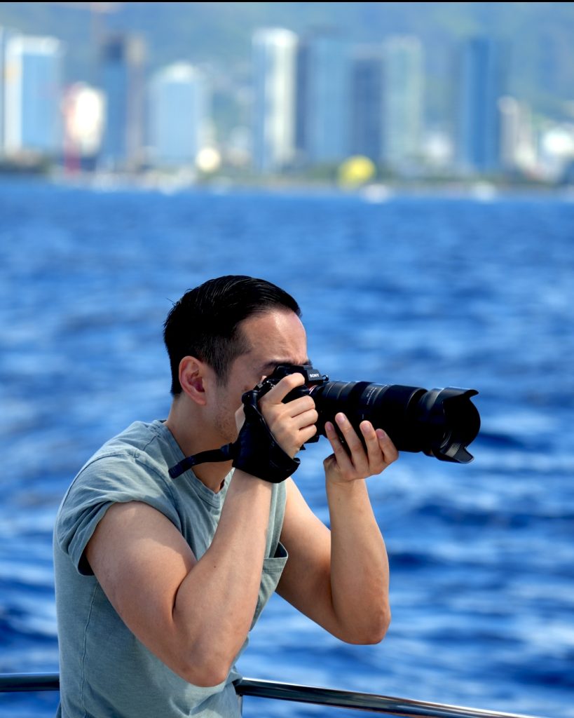 Photographer capturing wildlife with telephoto lens on boat