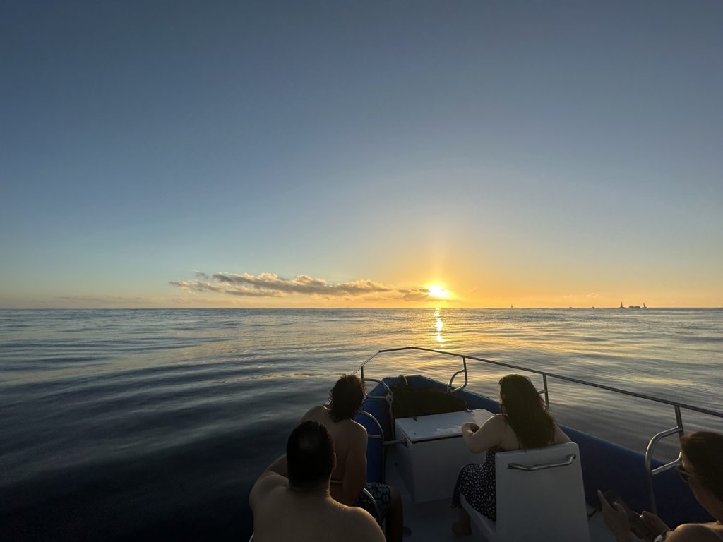 Group watching sunset from back of boat