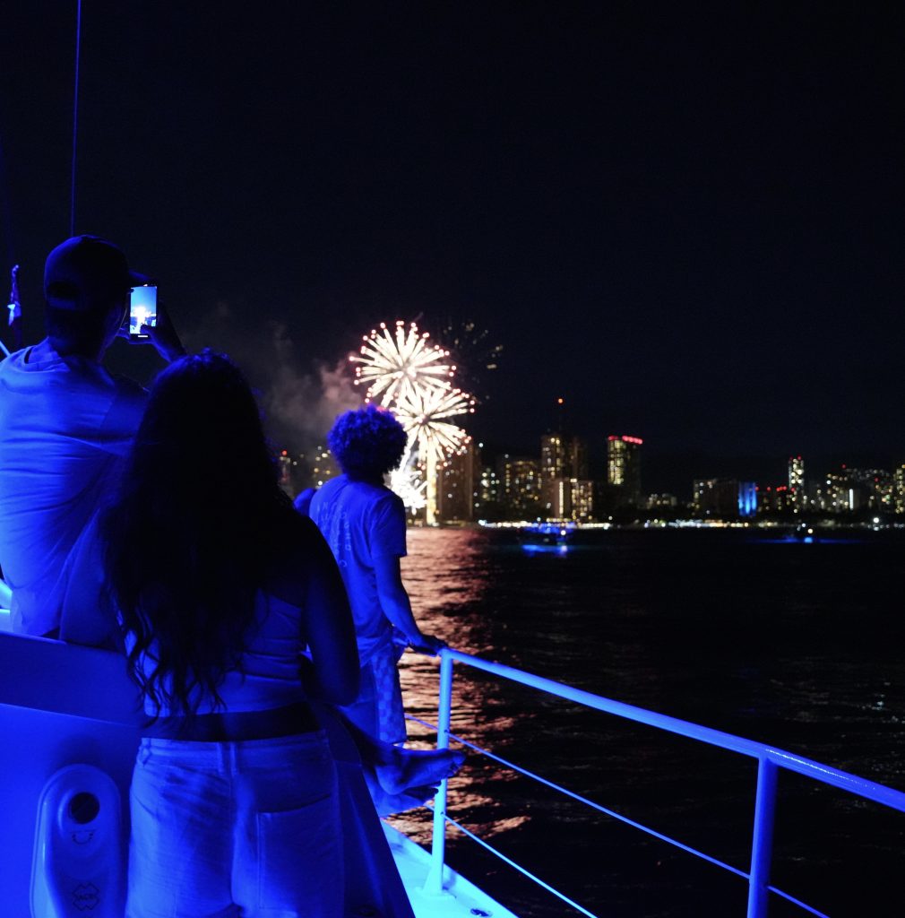 Guests watching Waikiki fireworks from a boat