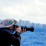 Photographer shooting whales with a telephoto lens
