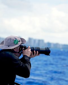 Photographer shooting whales with a telephoto lens
