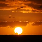 Bright orange sunset with sun on horizon