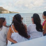 Friends in leis watching Diamond Head from boat