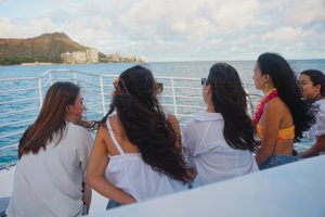 Friends in leis watching Diamond Head from boat