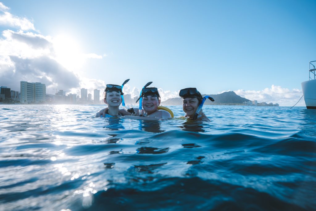 Snorkelers exploring the clear ocean water near Waikiki during a guided snorkeling adventure.