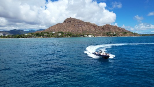 a small boat in a body of water with a mountain in the background