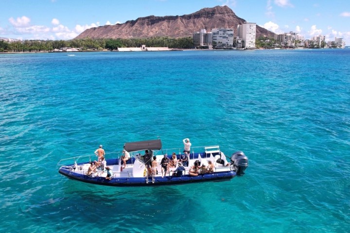 a blue and white boat sitting next to a body of water