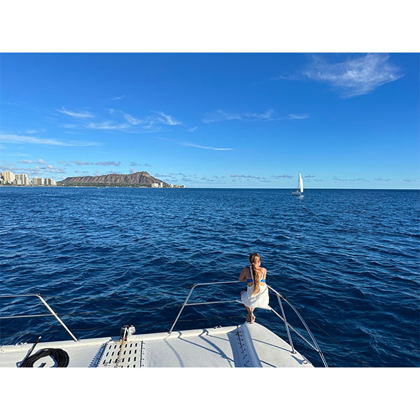 lady sitting on boat railing in ocean