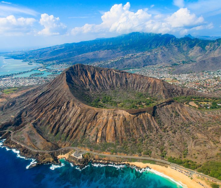 a body of water with Diamond Head in the background